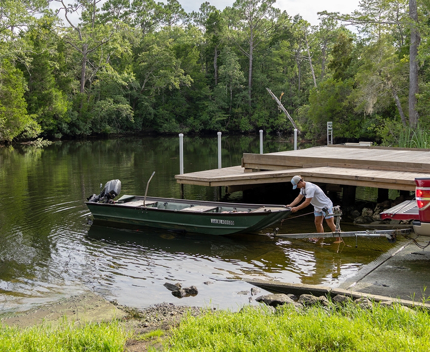 man launching boat at boat ramp
